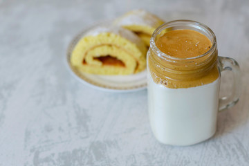 dalgona coffee and homemade biscuit on a light marble background