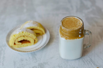 dalgona coffee and homemade biscuit on a light marble background