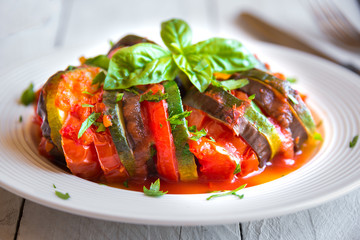Homemade ratatouille made with sliced vegetables: zucchini, tomatoes and eggplant. Delicious vegan dish