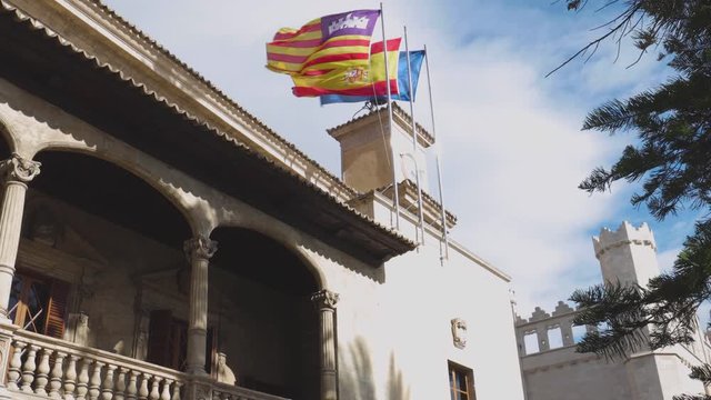 Catalan, Spanish and european flags thrashing in the wind at the consulate of the sea in Palma de Mallorca