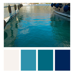 Close up of moored fishing boats in  marina harbor in a colour palette, with complimentary colour swatches