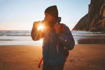 Man walking on beach enjoying sunset ocean view travel vacations sustainable tourism outdoor...