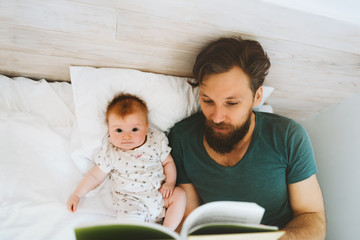 Father and baby daughter reading book fairytale at home lifestyle dad teaching child infant parent...