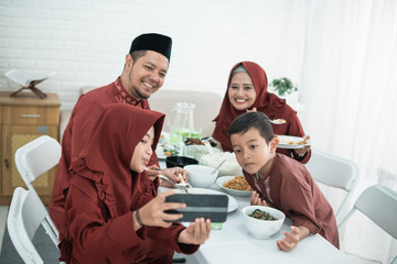 Selfie with family when breaking fast together. Muslim family sit to eat when breaking fast together at home