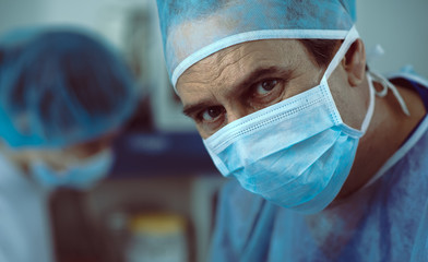 Experienced surgeon working on patient with assistants