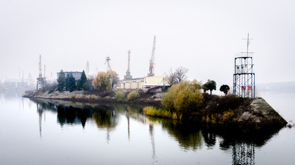 Disused cranes on a boat dock island along the river Danube on a misty morning, Ruse Bulgaria