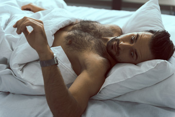 Fototapeta na wymiar Handsome man checking time after waking up