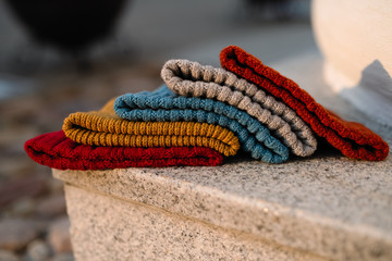 knitted hats of different colors lie on a marble slab