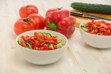 Salad of fresh green cucumbers, red tomatoes and bell peppers. Vegetables cooking ingredients. Gluten-free, lactose-free healthy vegan food, clean eating, Side view