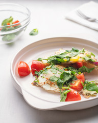 Fried eggs with tomatoes on a light plate for breakfast