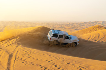 Sports rally in sand dunes of the desert Extreme tourist trip on a desert SUV with a group of tourists