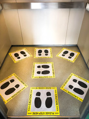 Elevator in the building with the footprint sign for social distancing standing to avoid virus Covid-19