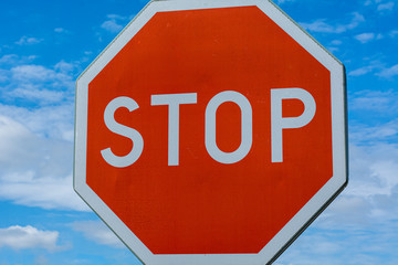 Obraz premium Red stop sign with a vibrant blue sky in the background