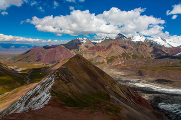 Snowy mountain peaks. Scenic landscape. Beautiful nature. Red sand.