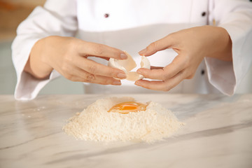 Obraz na płótnie Canvas Chef cooking dough at table in kitchen, closeup