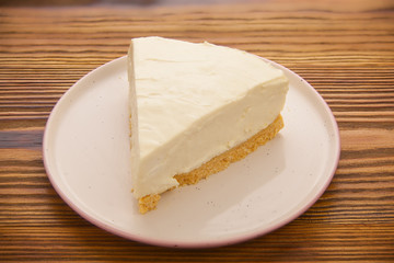 classic cheesecake on white plate on  wooden table