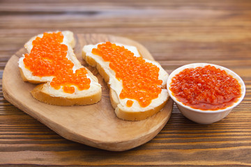 delicious appetizing sandwich with red caviar on  wooden