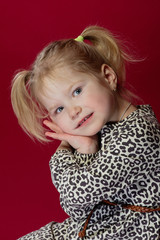 little girl folded her arms near her face, looking at the camera, tilted her head