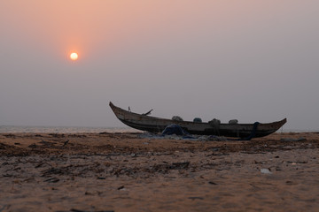 Traditional fishing boat at Ghana coast with sun