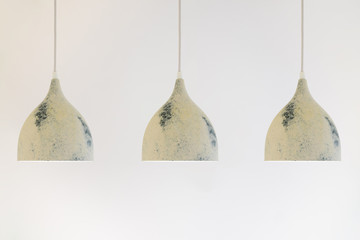 three ceiling lights on a long wire hanging from the ceiling on a white background