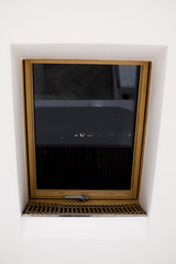 window with a wooden frame in a white wall with a view of the night city