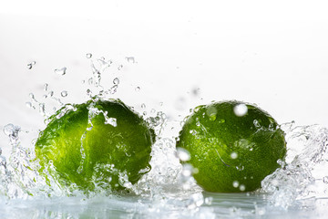 lime with splashes and streams of water on a black or white background isolated