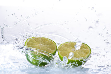 lime with splashes and streams of water on a black or white background isolated