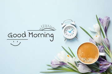 Cup of coffee, crocuses and alarm clock on light background, flat lay. Good morning