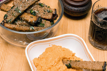 Beer snack fried croutons with cheese sauce on wooden board. Rye bread croutons with garlic, oil and salt.