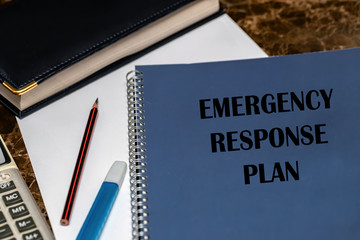 ERP as an emergency response procedure, the text is written on a blue book lying on the office Desk