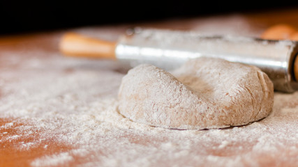 pizza dough on the table with more products to make the pizza