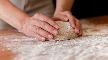 a person kneading the whole pizza dough 