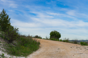 Fototapeta na wymiar ascending dirt path with blue sky