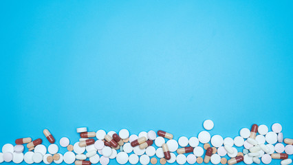 Many antiviral tablets on blue background, Blank for design. Top view.