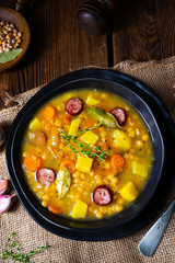 Rustic pea soup with bacon and sausages
