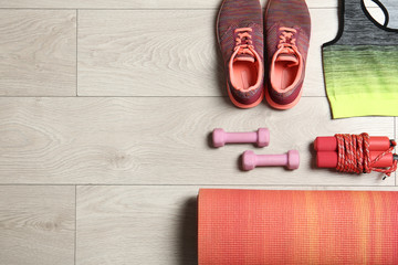 Set of fitness equipment and accessories on wooden background, flat lay. Space for text