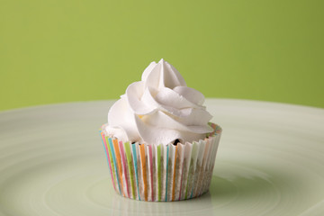 Cupcake with frosting on green background,copy space