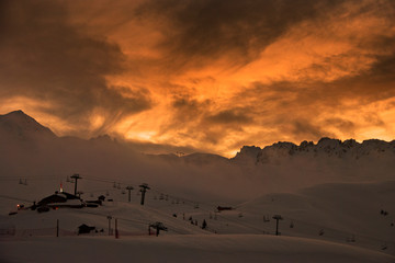 Fototapeta na wymiar Sun setting over Les Arcs 2000 paradiski ski area Massif de La Vanoise, high Tarentaise valley Savoie France