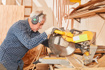 Senior Mann als Handwerker an der Kappsäge