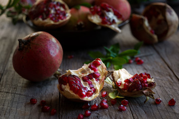 Fresh organic pomegranate fruit with leaves on dark background