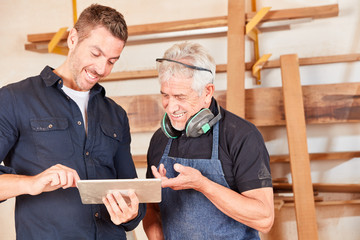 Junger Schreiner und Meister mit Tablet