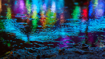 Blue reflections in the water when it rains at a fun fair