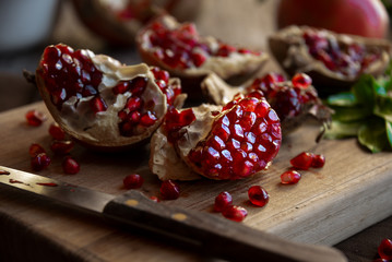 Fresh organic pomegranate fruit with leaves on dark background