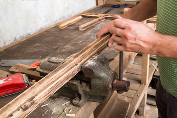 Male carpenter working on old wood in a retro vintage workshop.