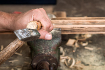 Male carpenter working on old wood in a retro vintage workshop.
