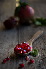 Fresh organic pomegranate fruit with leaves on dark background