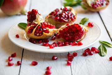 Fresh organic pomegranate fruit with leaves on white background