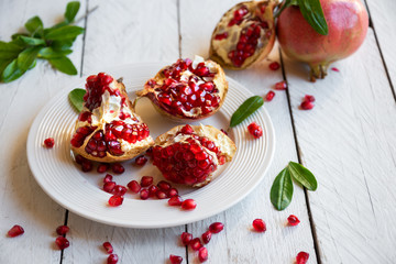 Fresh organic pomegranate fruit with leaves on white background