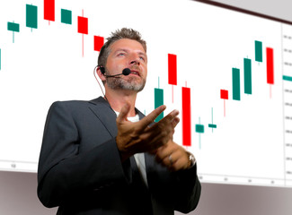 confident successful trader man with headset speaking at event coaching trading business at...