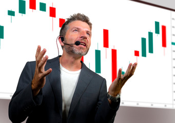 confident successful trader man with headset speaking at event coaching trading business at...